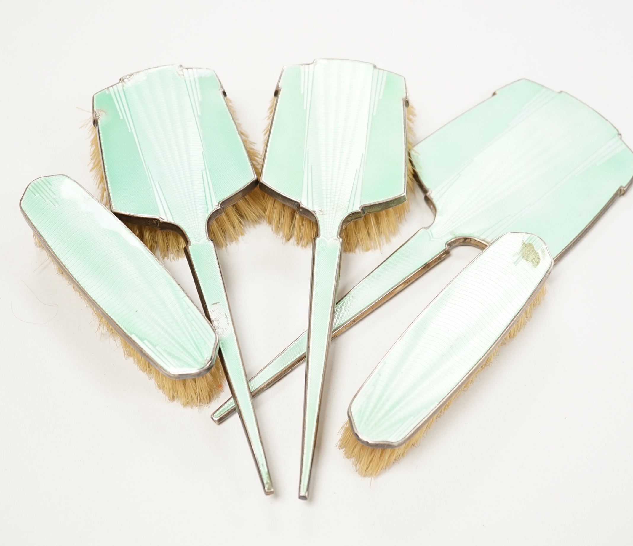 A George V Art Deco five piece silver and green enamel set mirror and brush set, W.G. Sothers Ltd.